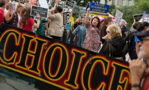 WASHINGTON, DC - JUNE 23: Pro-choice and pro-life protesters clash in front of the U.S. Supreme Court on a day where two important decisions on immigration and affirmative action were handed down by the court, on June 23, 2016 in Washington, DC. A decision in the case over a Texas law requiring clinics providing abortion services to meet the same building standards as walk-in surgical centers had been expected but was deferred. (Photo by Allison Shelley/Getty Images)