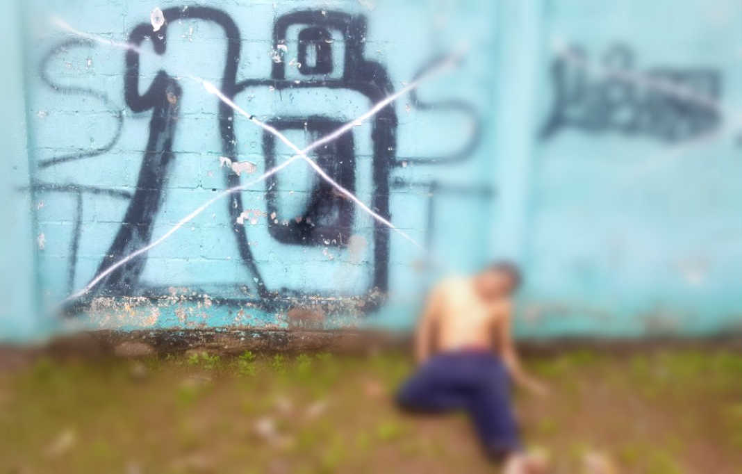 junto a grafiti de la pandilla 18