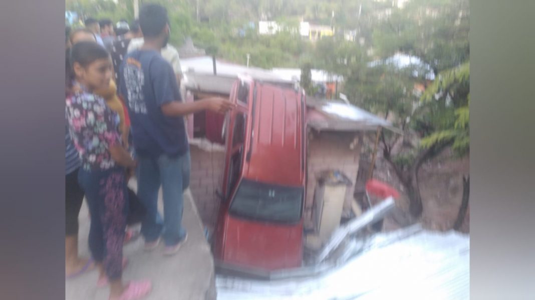 Carro cae sobre casa