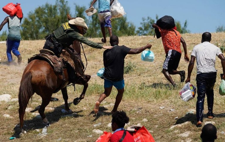 Migrante haitiano es atrapado por un guardia fronterizo.